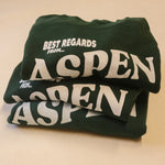 Green sweatshirt with 'Best Regards From Aspen' text on a beige background